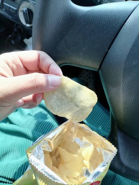 istock Eating potato chips in the bag on car 2050671605