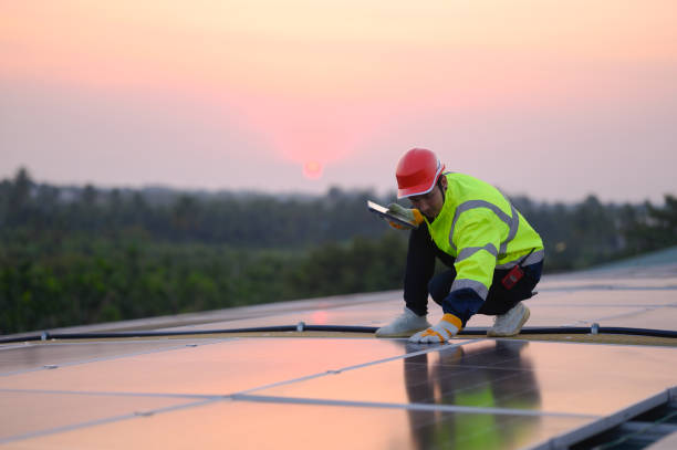 istock Male engineer works installing solar panels on the roof. Engineer or worker working on solar panels or photovoltaic cells on the roof of a business building. 2050672141