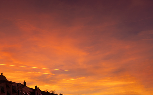 Wide panorama of a sunset with golden and orange colors predominating on clouds