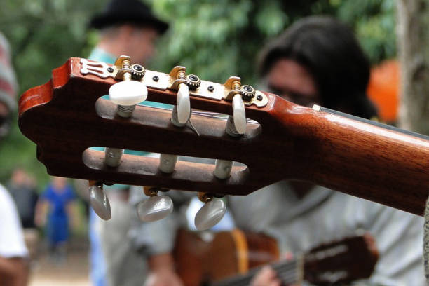 istock Guitar neck being played with 2 musicians in the background 2050673130