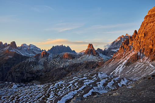 Italian alps - mountains range near the Tre Cime di Lavaredo during bleu hour. There is some snow on the mountaintops. There is a climber's hut on one of the hills