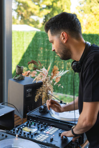 istock DJ setting up the mixing console before starting the concert 2050673815
