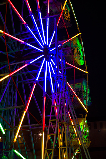 Neon colored illuminated ferris wheel  at festival and night market in Lampang