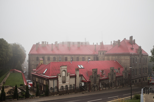 Old town in the fog. Roofs of houses on a foggy morning in Lviv. Old houses in the fog. Fire station with a red roof in the fog. Ukraine.