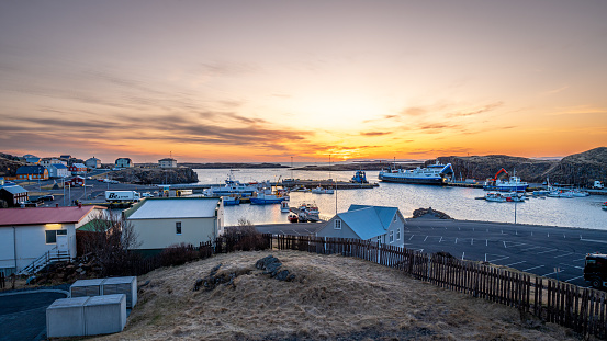 Stykkisholmur, Iceland – April 24, 2023: Scenic sunset view of Stykkisholmur with harbor in background