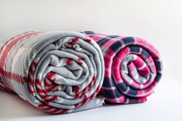 Rolled-up two different color and size fleece blankets on the white background