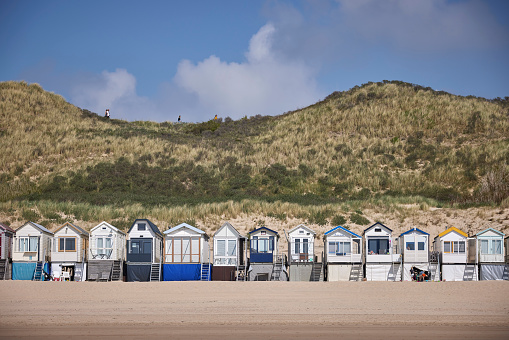 Colorful beach houses on a sandy beach under a blue sky on the North Carolina coast