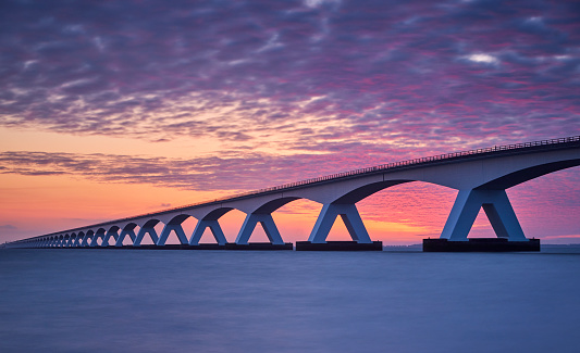 Zeeland Bridge, The Netherland during a beautiful and dramatic sunrise. The Zeelandbrug (build 1965) is a traffic bridge over the Oosterschelde with a total length of 5022 meters.