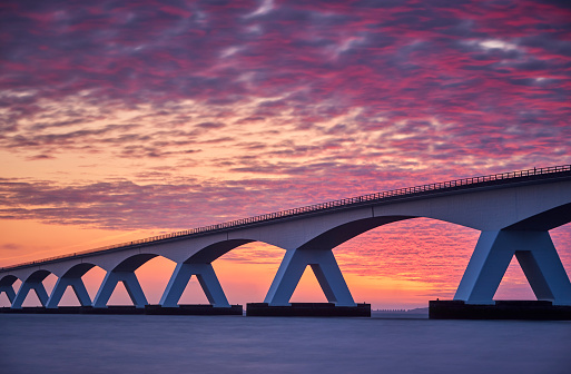 Zeeland Bridge, The Netherland during a beautiful sunrise. The Zeelandbrug (build 1965) is a traffic bridge over the Oosterschelde with a total length of 5022 meters.