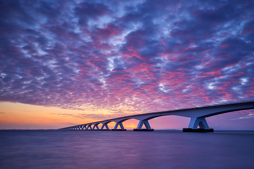 Zeeland Bridge, The Netherland during a beautiful and dramatic sunrise. The Zeelandbrug (build 1965) is a traffic bridge over the Oosterschelde with a total length of 5022 meters.