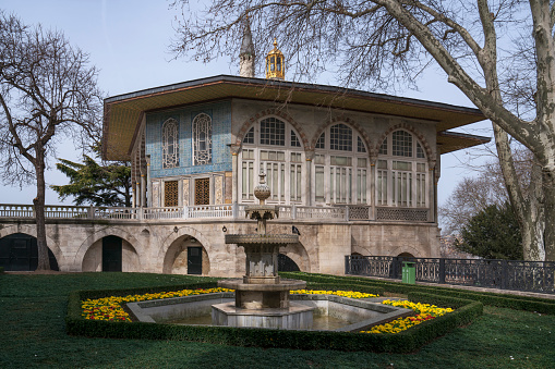 Istanbul, Turkey, 02.27.2023: View of the Baghdad Pavilion against the background of the fountain in the Arslanli garden in the fourth courtyard of the Topkapi Palace on a sunny day