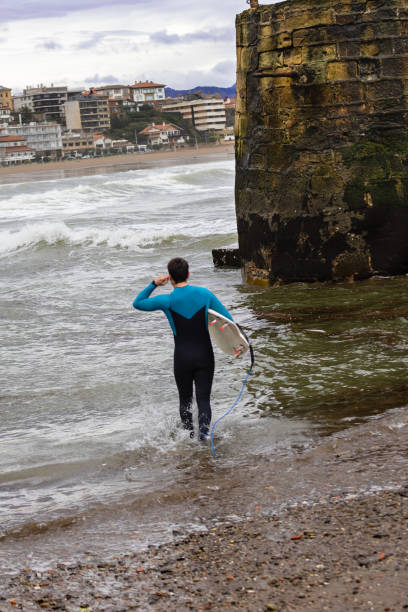istock Surfer heading into the surf with board in hand, copy space. 2050775517