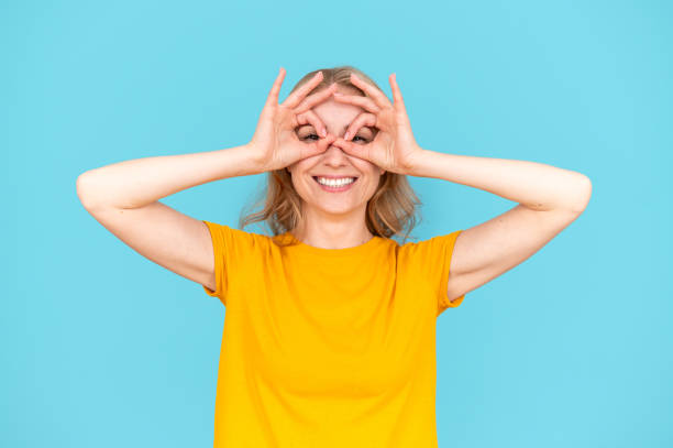 istock Smiling woman making funny faces, binoculars glasses shape gesture 2050811048