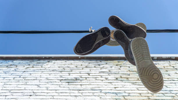 Old sneakers and shoes hanging on a wire