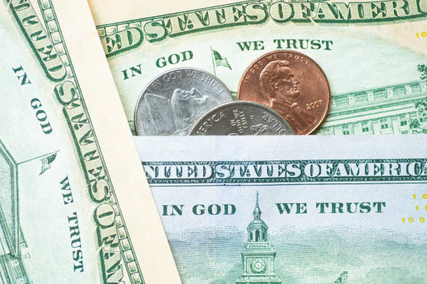 USD bills and coins with the sentence 'in God we trust' written on them
