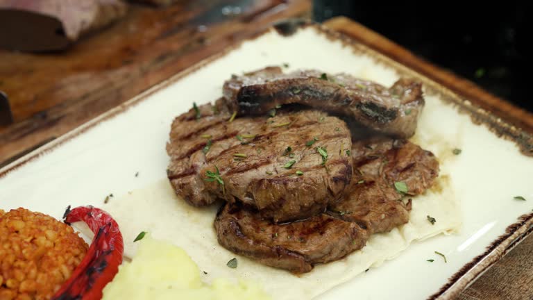 Fresh juicy tenderloin slices on the serving plate. thyme falls over the tenderloin.