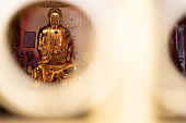 Golden Buddha statue in Longshan Temple, Taiwan. Taking a photo through the hole in the temple gate.