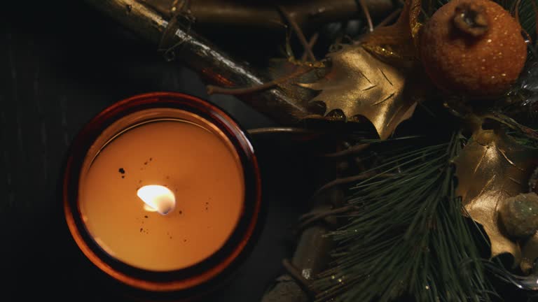 Burning candle in dark glass jar. Halloween Xmas witchcraft atmosphere.