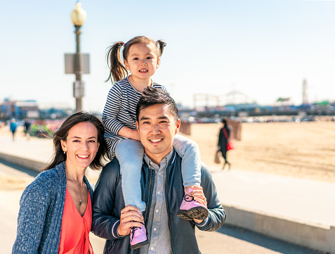 A portrait of a young family on Santa Monica Beach in California.