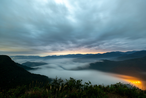 The sea of clouds on a quiet moonlit night makes you feel unpredictable. View of the mountains surrounding Emerald Reservoir. Xindian District, Taiwan.