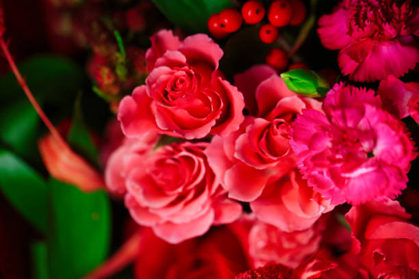 A beautiful arrangement of pink and red flowers in a vase, with plenty of copy space.