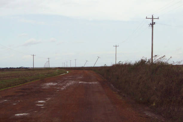 istock Dirt road very clogged with some downed electricity poles 2051002348