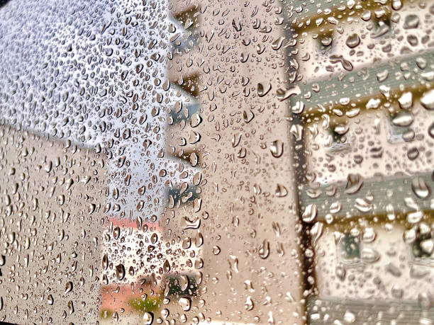 istock Wet glass with raindrops, and building in the background 2051022307