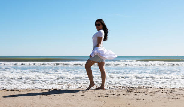 Young lady at beach walking beside the sea