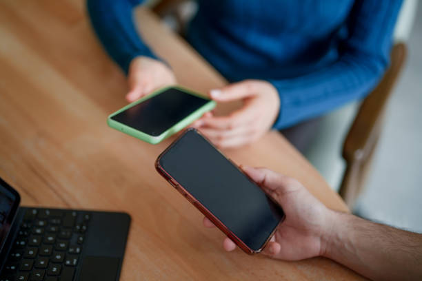 istock Part of a series: people connecting through mobile phones on office table. 2051071623