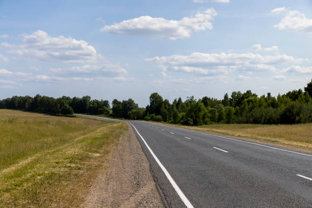 istock paved road along and blue sky 2051072793
