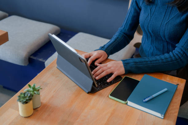 istock Part of a series: Asian woman working on digital tablet in cafeteria. 2051092589
