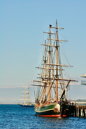 Two masted sailing ships in the Port Angeles harbor on display. The first ship is the Lady Washington