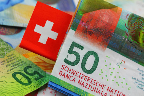 istock CHF, Swiss banknotes and Swiss flag 2051114939