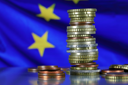 This is the currency of the European Union. The stack of coins is shown against the background of the European flag. This theme can be used to illustrate many different financial topics.