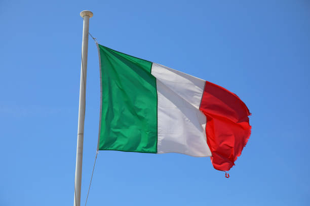 istock Italian flag waving against blue sky 2051116550