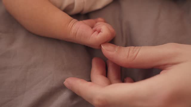 Tender Connection: Mother's Hand and Baby's Touch