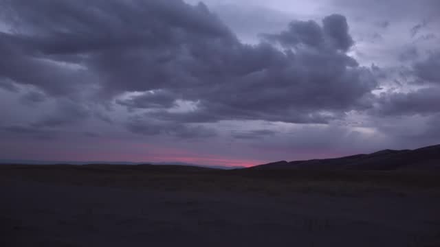 Red sunset over the tops of large sand dunes. Great Sand Dunes National park. COLORADO. USA