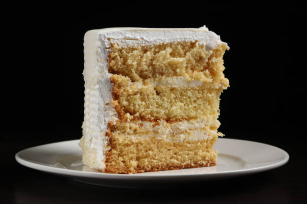 istock A piece of white cake with marzipan under dark lighting. Close-up 2051154308