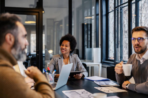 istock A multicultural manager is sitting at boardroom with her coworkers and collaborating on a project. 2051158513