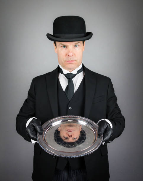 サービングトレイを保持する英国の執事 - silver platter concierge waiter butler ストックフォトと画像