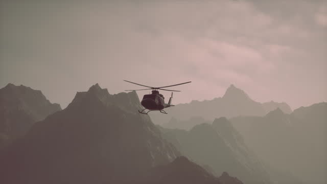 A helicopter is flying over a mountain range