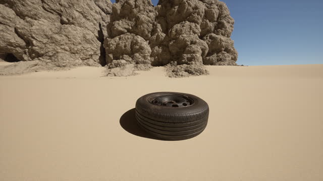 A tire sitting in the middle of a desert