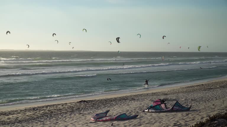 Kite Surfers Riding Waves at Golden Sunset