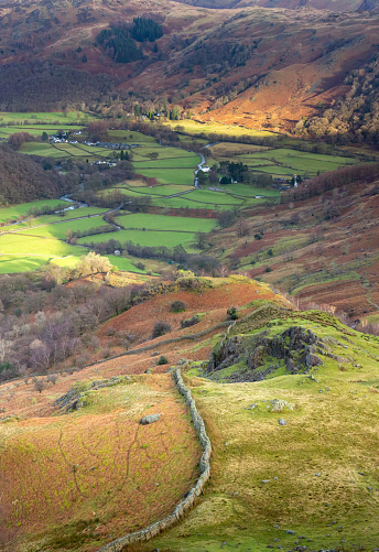 A patchwork of fields and drystone walls in the valley bottom from the fells above Borrowdale in the English Lake District in winter time.