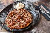 Ferrero Rocher Waffle with chocolate, whipped cream, knife and fork served in dish isolated on dark background top view cafe dessert food