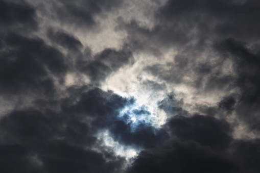 A partial solar eclipse of October 25, 2022 captured through moody dark clouds, the maximal phase visible from Europe, Romania.