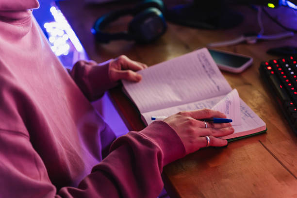 istock Unrecognizable young student turning pages of his notebook in his room setup 2051291492