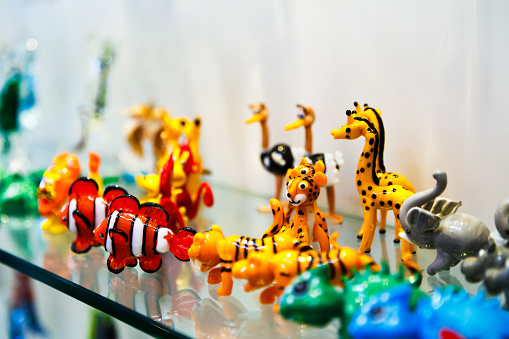 Colorful souvenirs from the world-famous Murano glass. Traditional Murano glass animal figures in branded gift shop, Murano island, Venice, Italy.