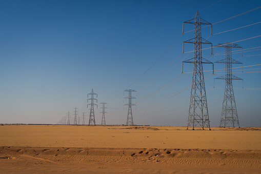 electric power generated  from the Aswan Dam along the desert heading south in Egypt