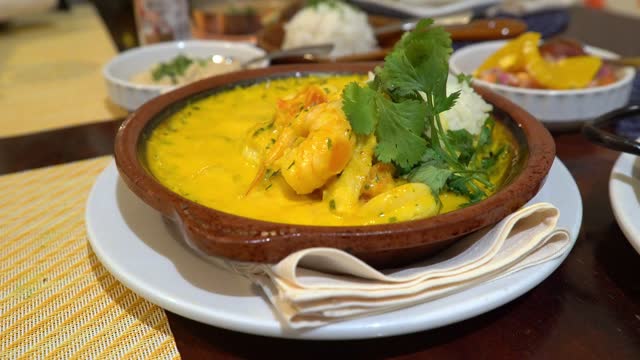 Traditional shrimp moqueca served in a clay pot at a brazilian restaurant